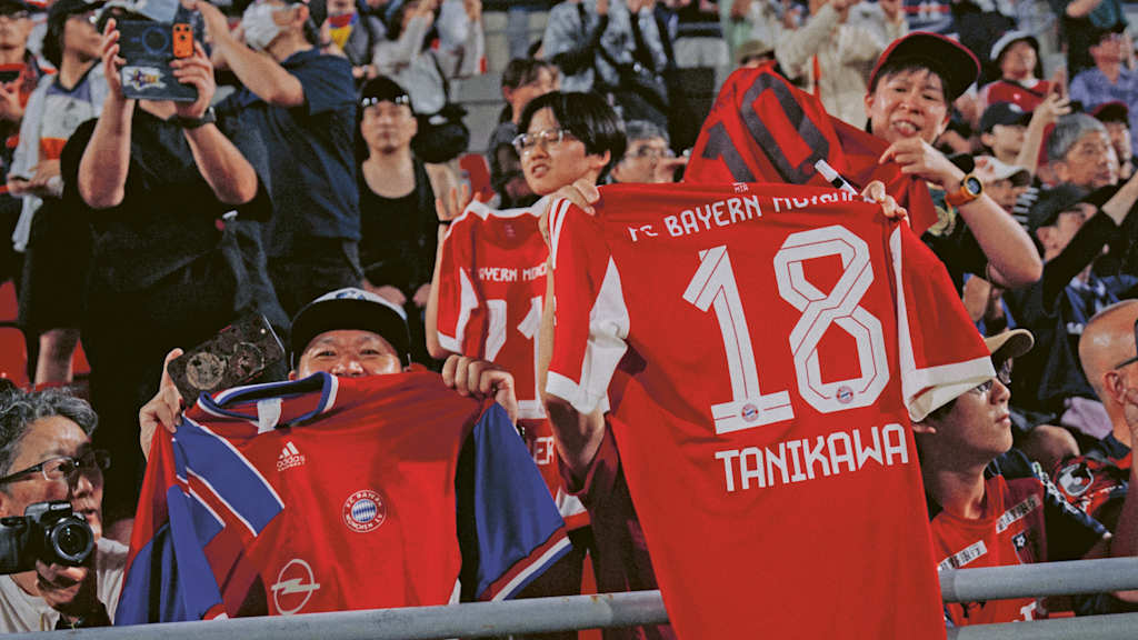Fans halten Trikots von Momoko Tanikawa in die Höhe.
