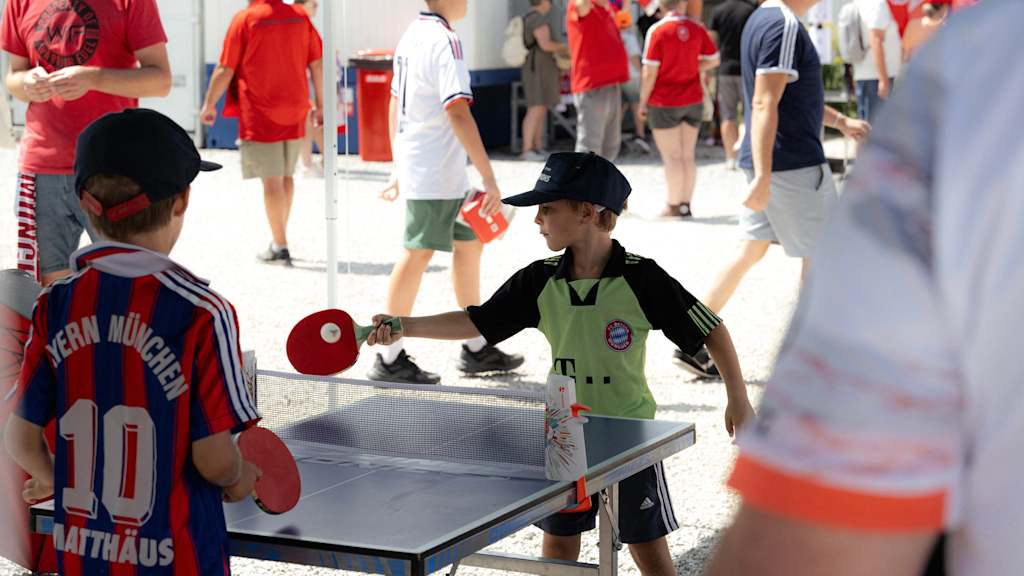Ein junger FCB-Fan spielt auf dem Fanfest in Unterhaching Tischtennis.