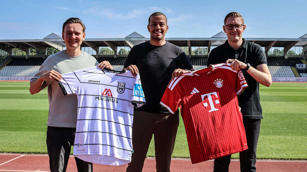 Max Gärtner (li.), Dominik Schwärzel (mit.) und Max Obermaier (re.) halten zwei Trikots hoch.