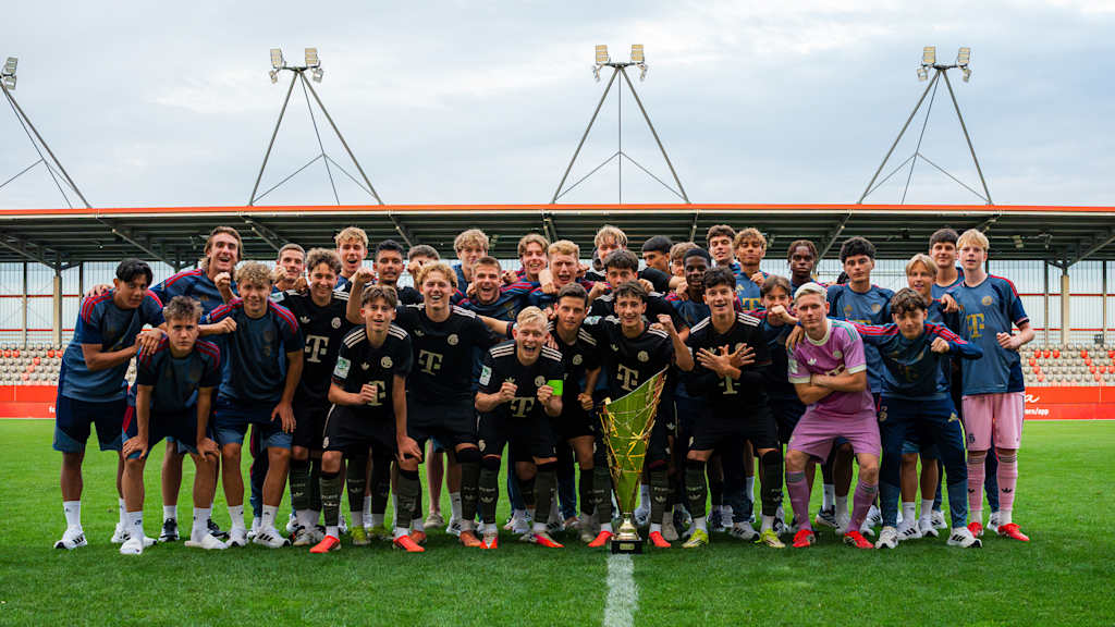 Die U19 des FC Bayern posiert mit einem goldenen Pokal für ein Siegerfoto.