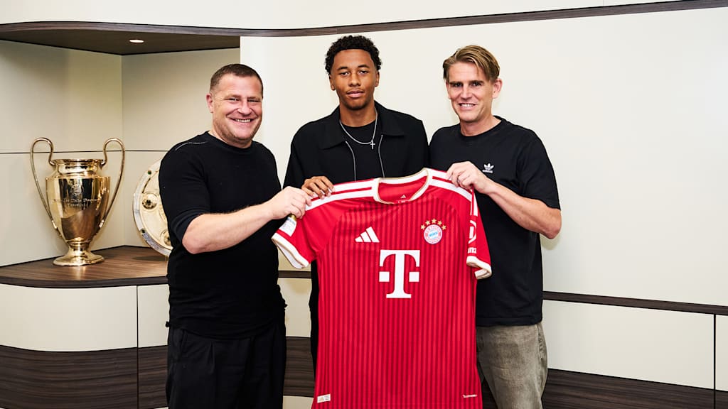 Max Eberl, Cassiano Kiala und Christoph Freund halten ein rotes FC Bayern Trikot