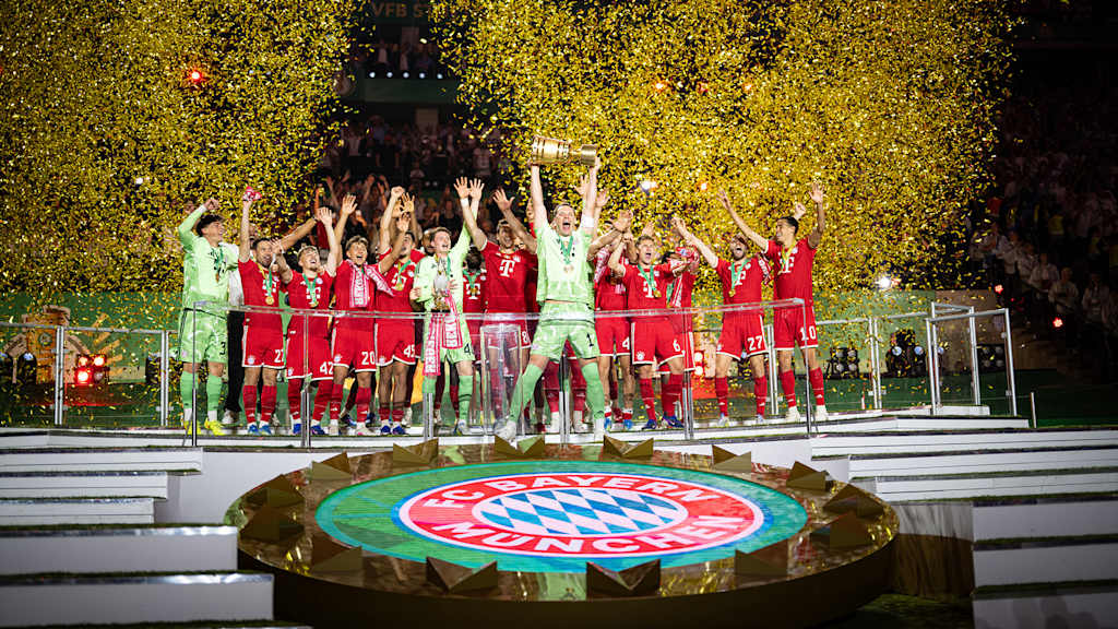 Die Mannschaft des FC Bayern reckt den DFB-Pokal in die Höhe.