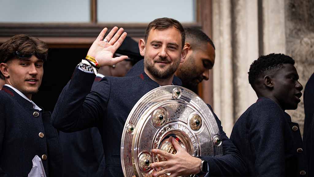Rene Maric auf dem Rathausbalkon mit der Meisterschale winkt