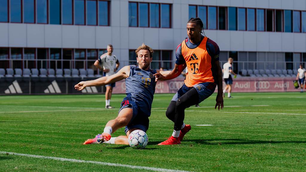 Harry Kane grätscht Michael Olise den Ball vom Fuß im Training des FC Bayern