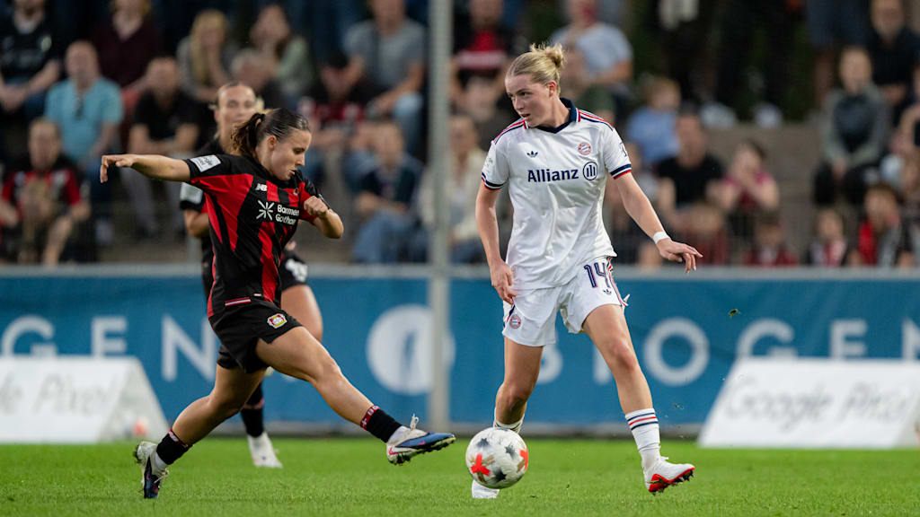 Alara mit dem Ball am Fuß, während eine Leverkusenerin auf sie zustürmt.
