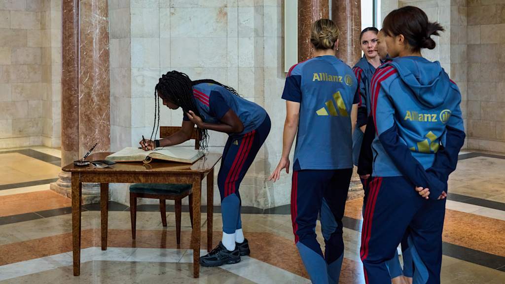 Die Spielerinnen des FC Bayern tragen sich ins Goldene Buch ein