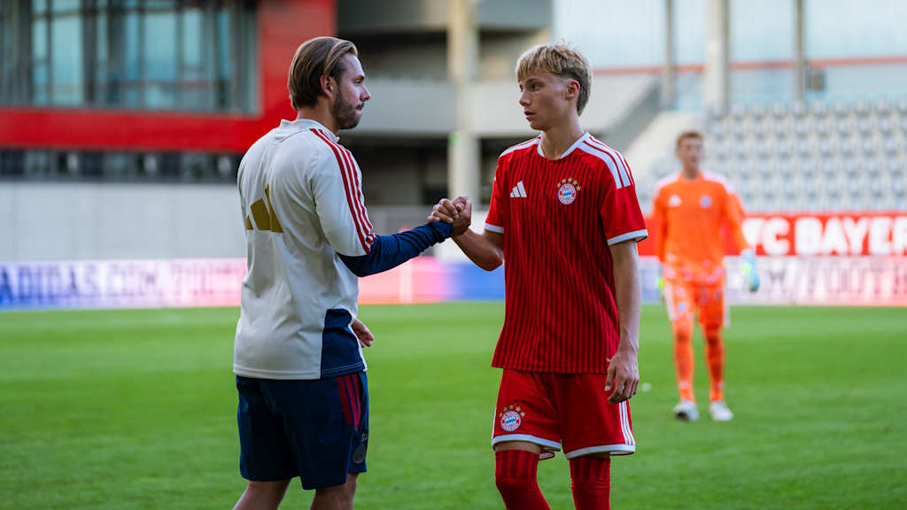 Sebastian Weiß klatscht mit einem Spieler ab.