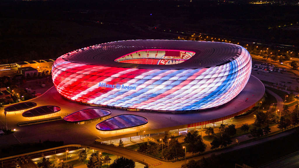 Allianz Arena leuchtet bei Nacht mit Klimastreifen