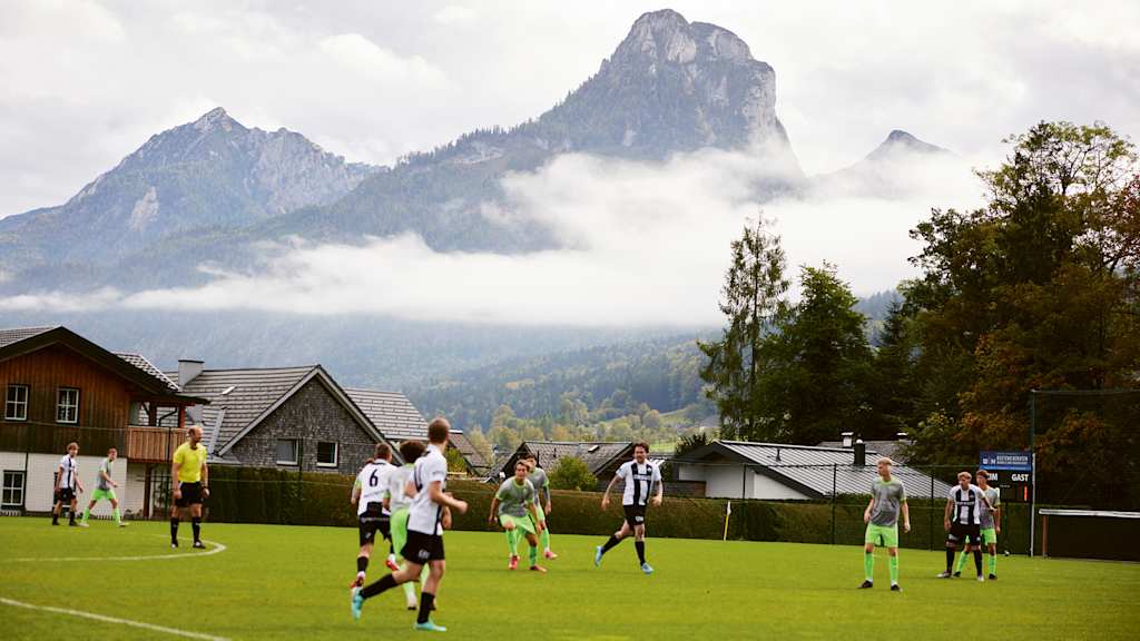 Jugendliche spielen Fußball auf dem Platz in Abersee, Österreich
