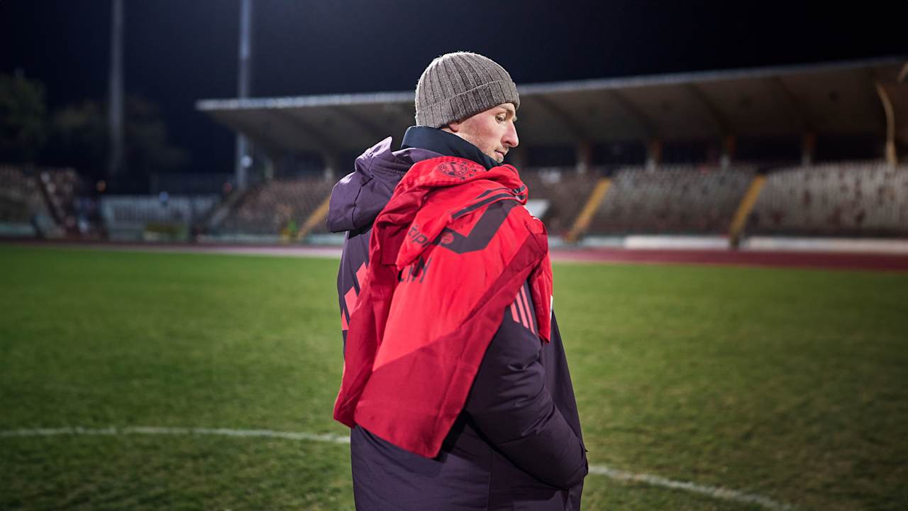 Timo Kern seitlich von hinten, schaut über seine Schulter, über welcher ein FC Bayern-Trikot hängt.