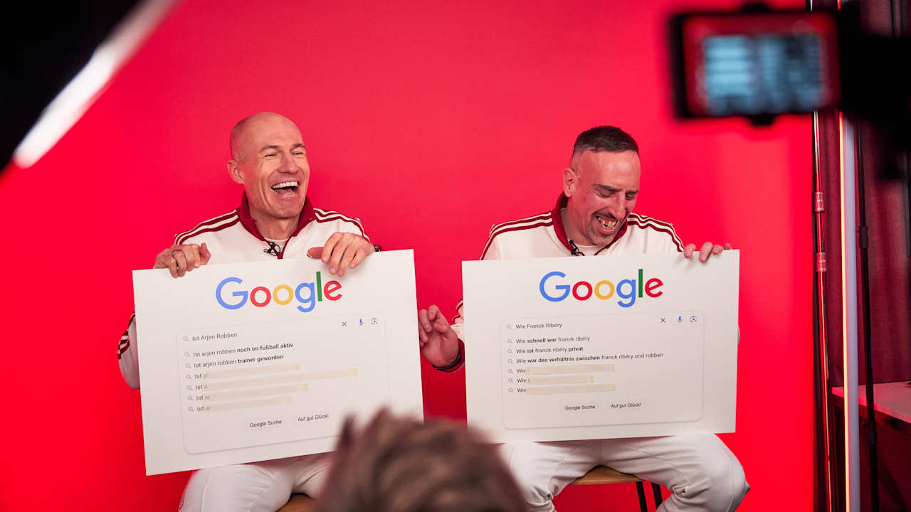 Arjen Robben und Franck Ribéry sitzen nebeneinander und lachen.