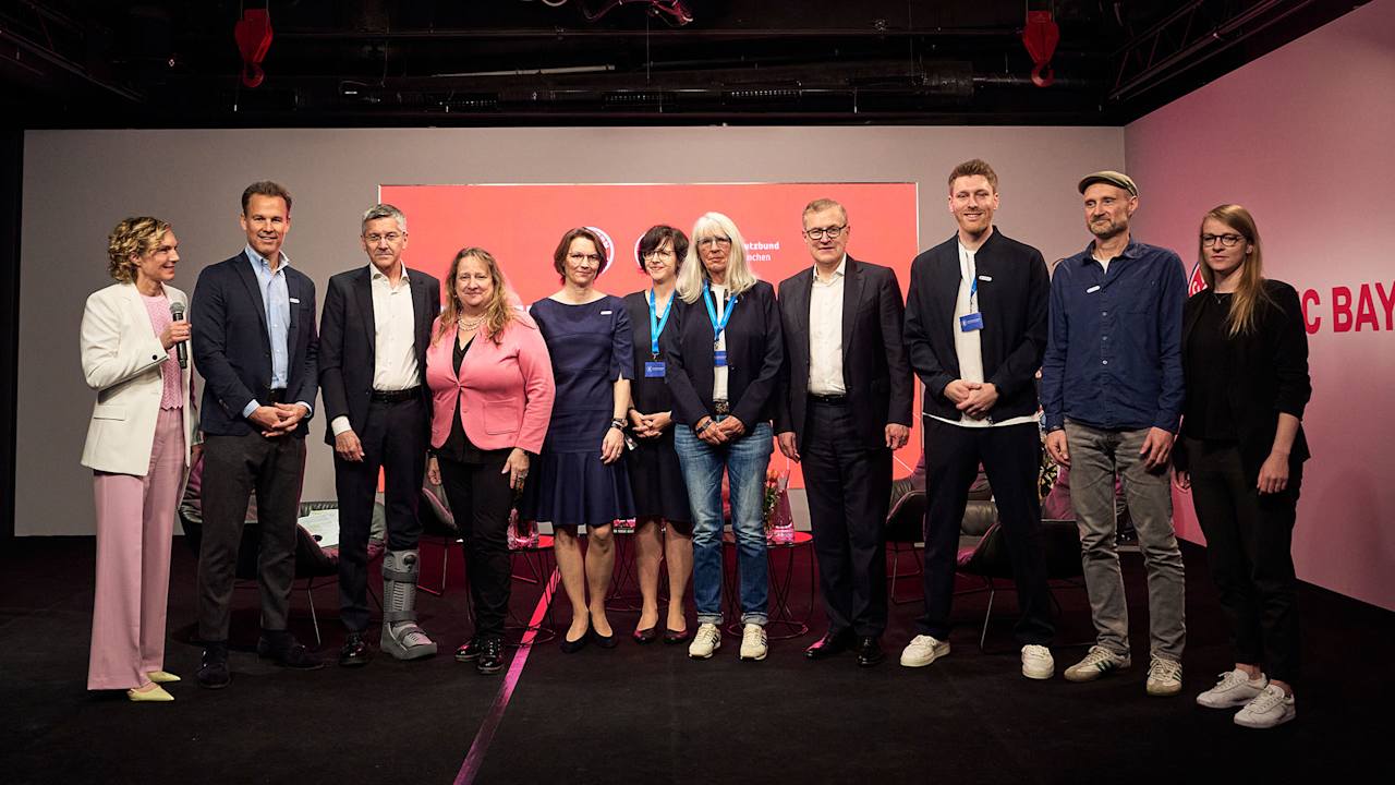 Gruppenfoto der Personen, die eine Spielerfigur des FC Bayern aus dem Museum ersteigert haben.