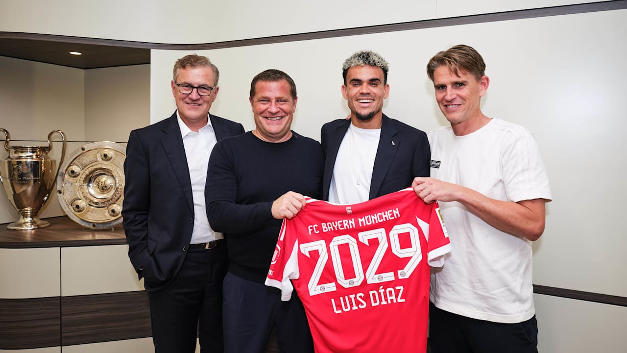 Jan-Christian Dreesen, Max Eberl, Luis Díaz und Christoph Freund halten ein Trikot mit 2029 Luis Diaz hoch.