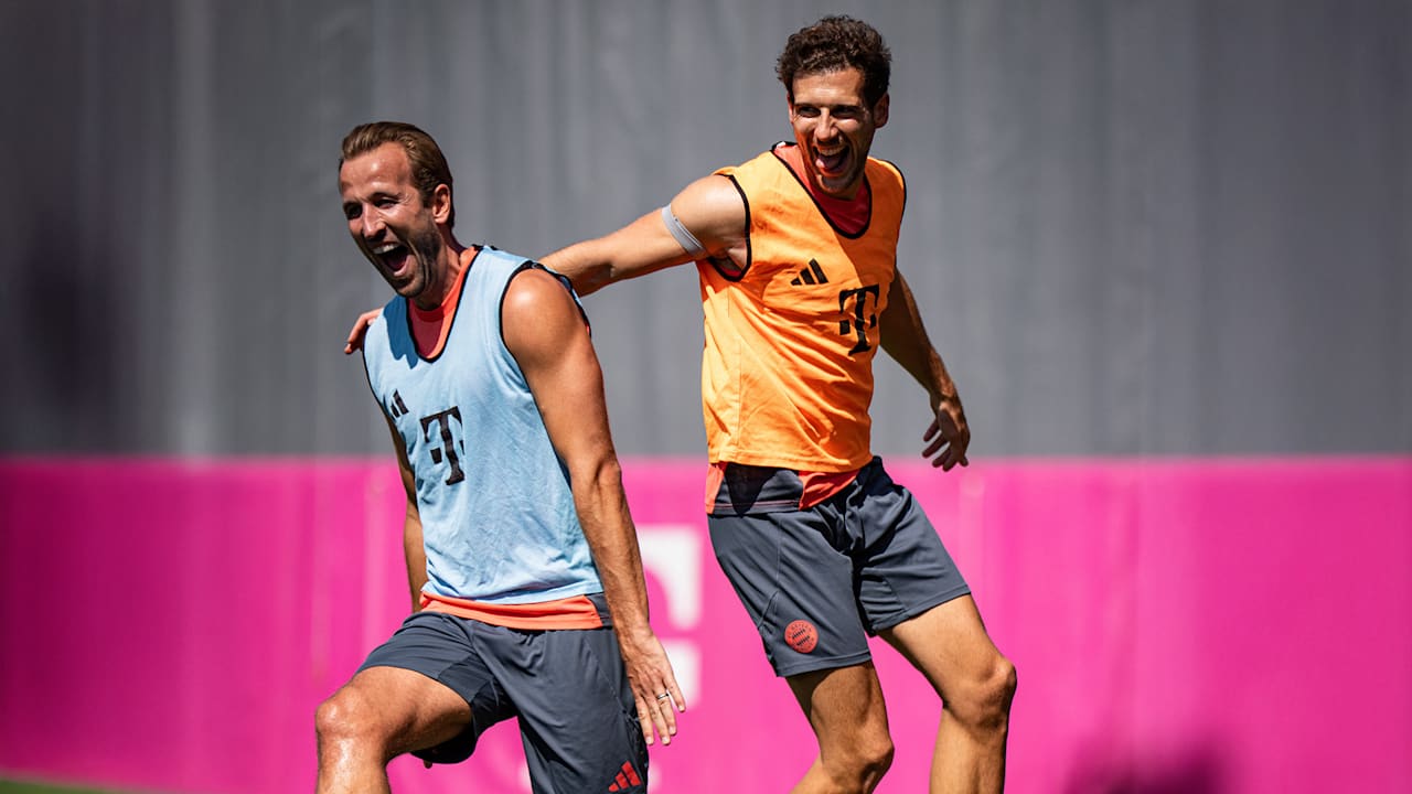 Harry Kane und Leon Goretzka lachend beim Warmlaufen im Training des FC Bayern vor dem Pokalspiel in Wiesbaden.
