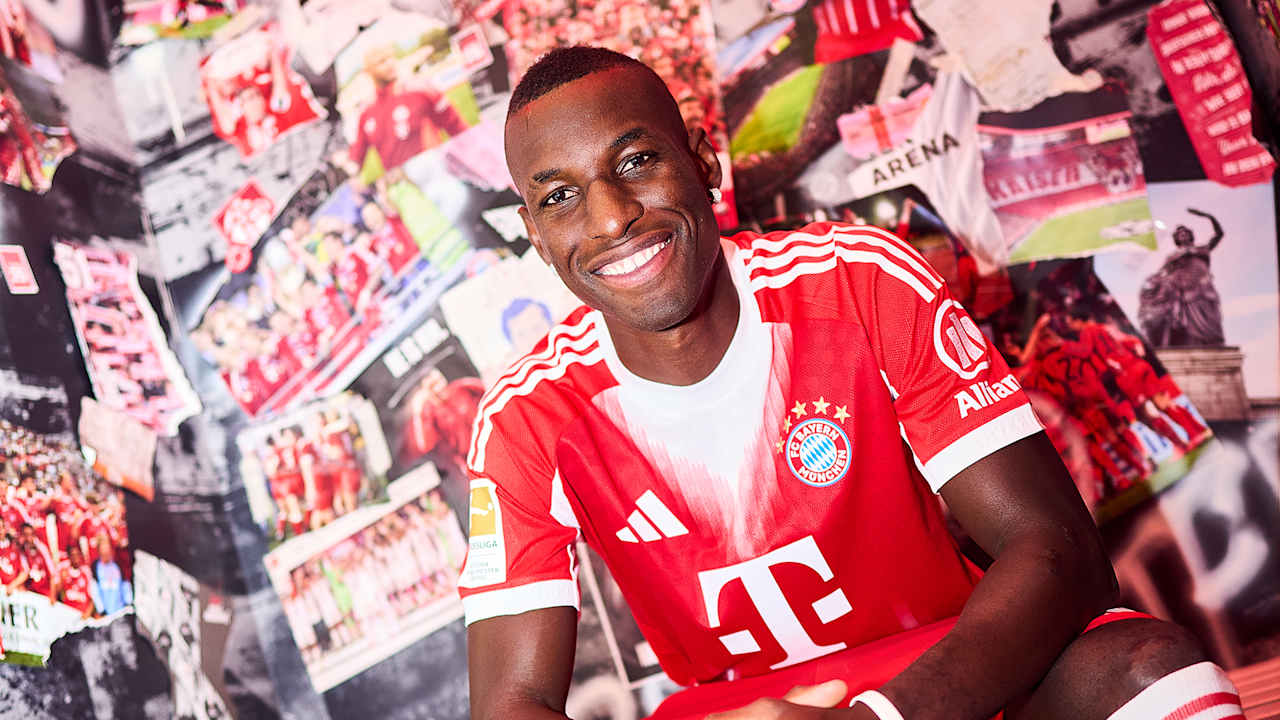 Nicolas Jackson trägt ein FC Bayern Trikot und lacht