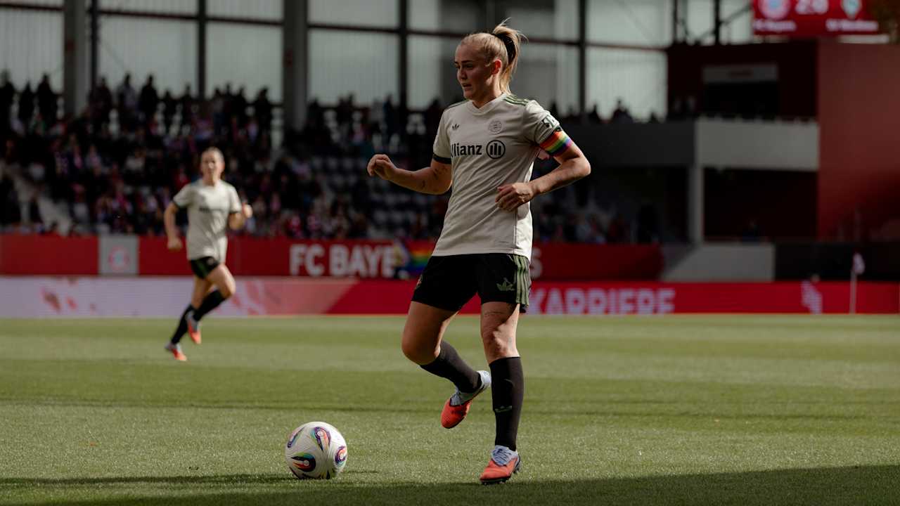 Georgia Stanway mit Kapitänsbinde und Wiesn-Trikot am Ball.