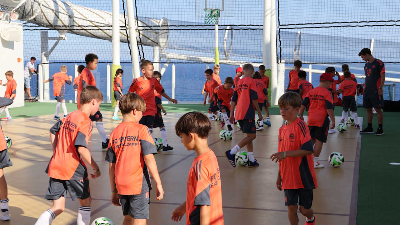 KIDS CLUB-Mitglieder spielen auf dem Deck des Schiffes Fußball.