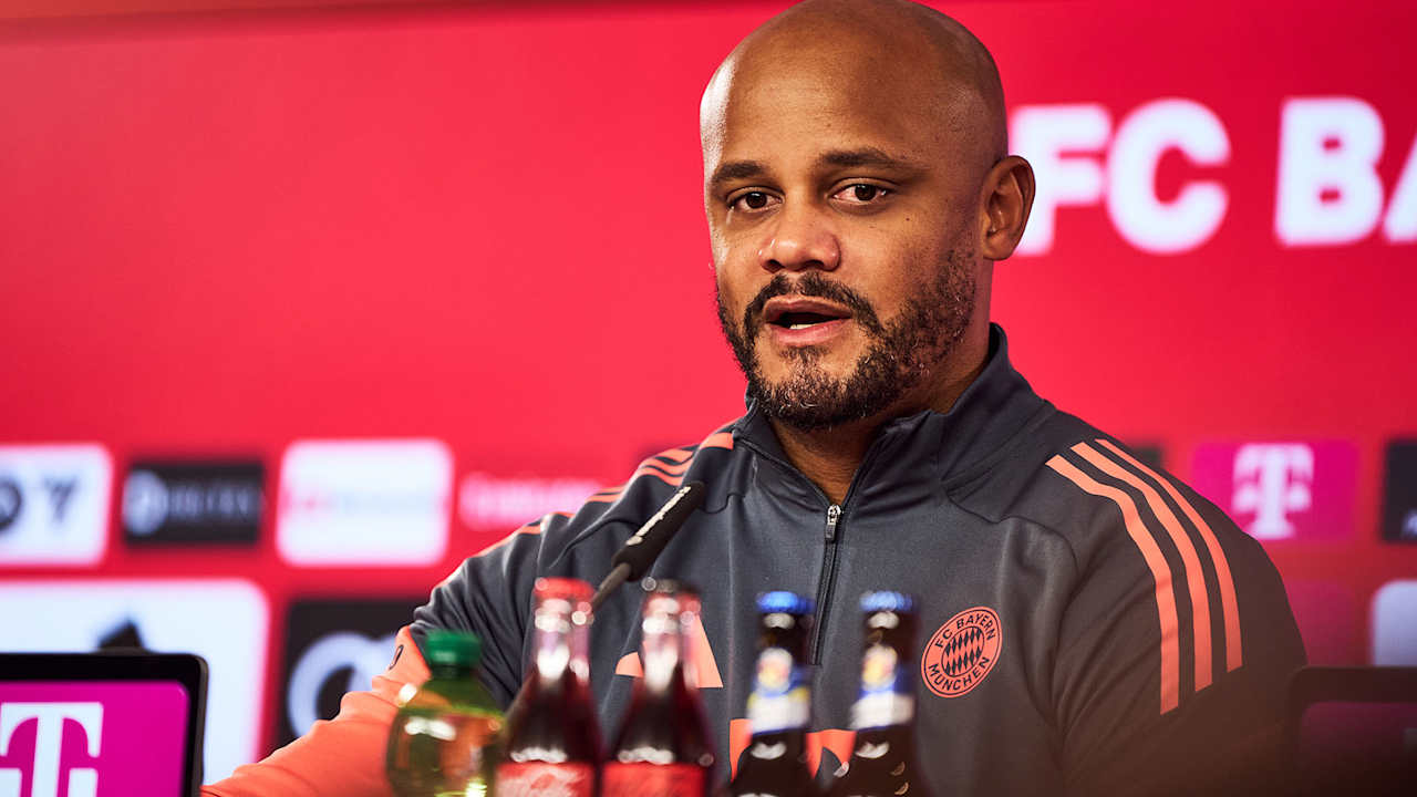 Durch den Bildschirm einer Videokamera sieht man Vincent Kompany auf dem PK-Podium.