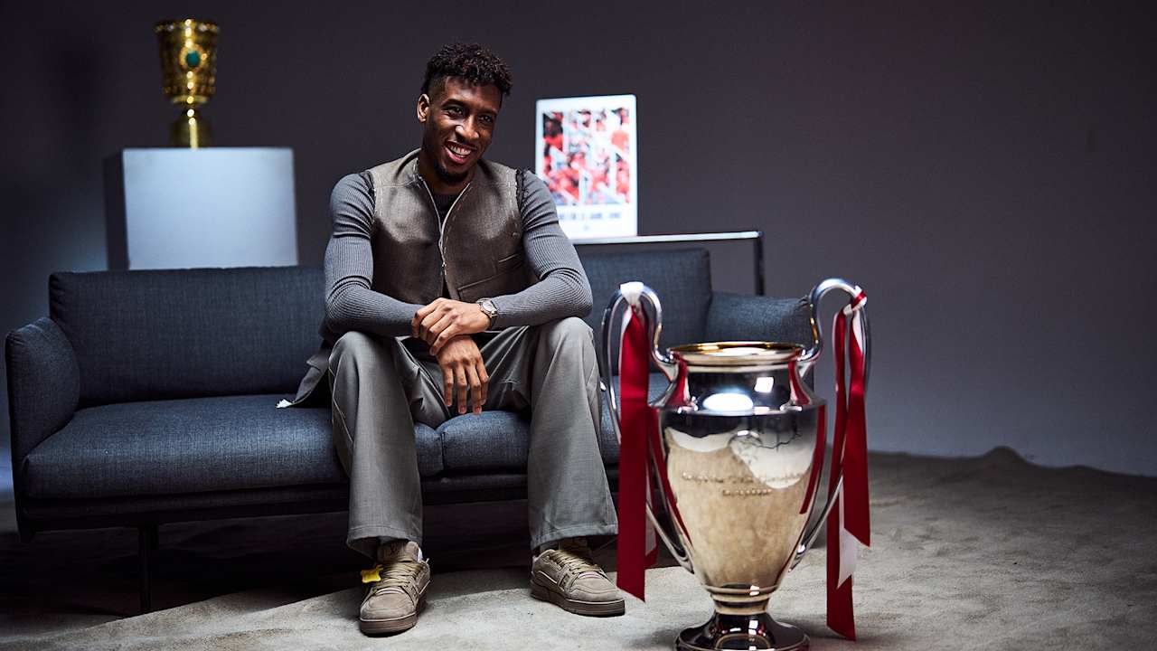 Kingsley Coman being interviewed on a couch with the Champions League trophy in front of him
