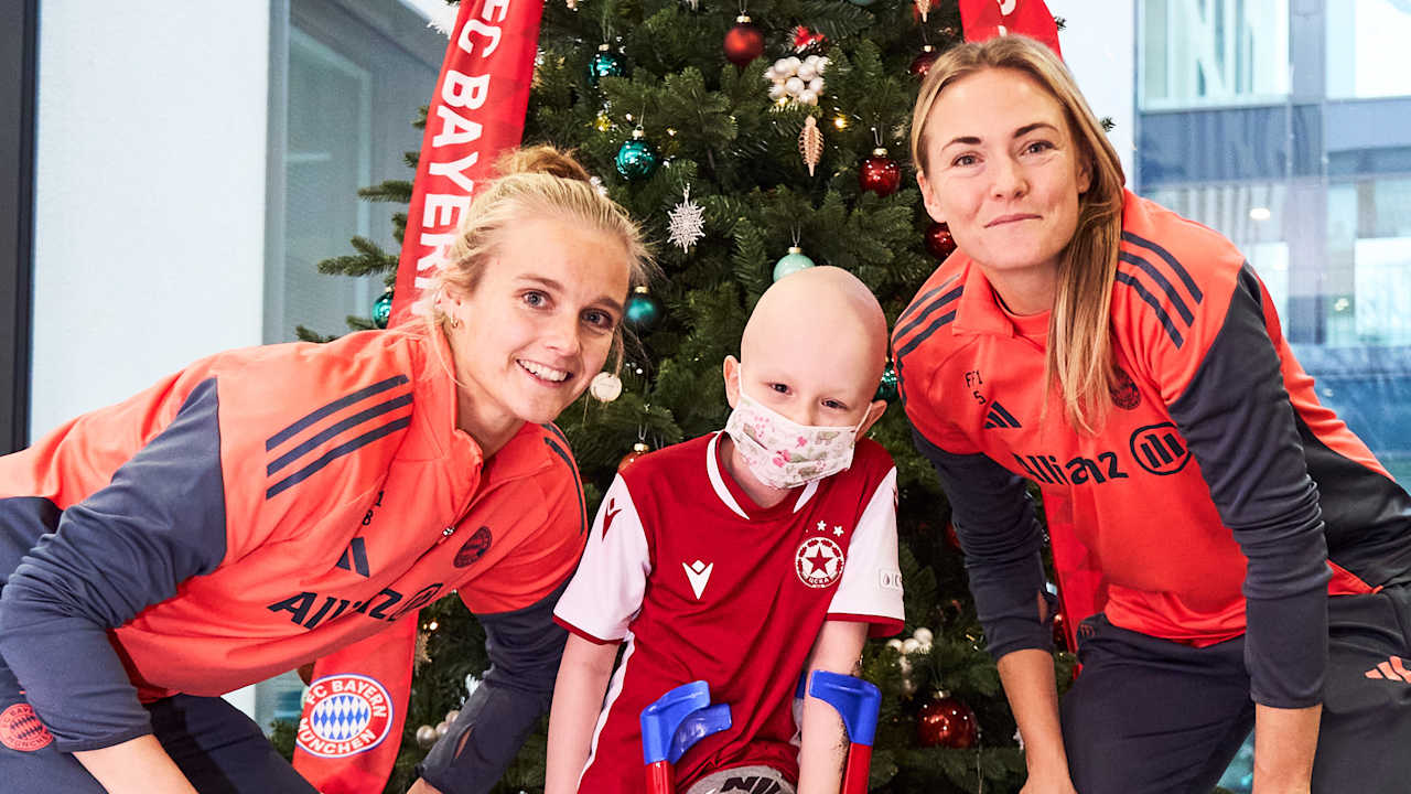 Anna Klink und Magdalena Eriksson machen ein Foto mit einem Kind.