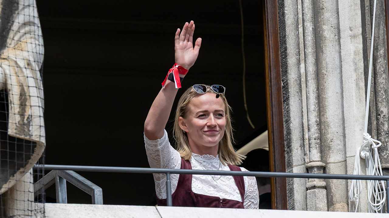 Lea Schüller winkt den Fans vom Münchner Rathausbalkon aus zu.