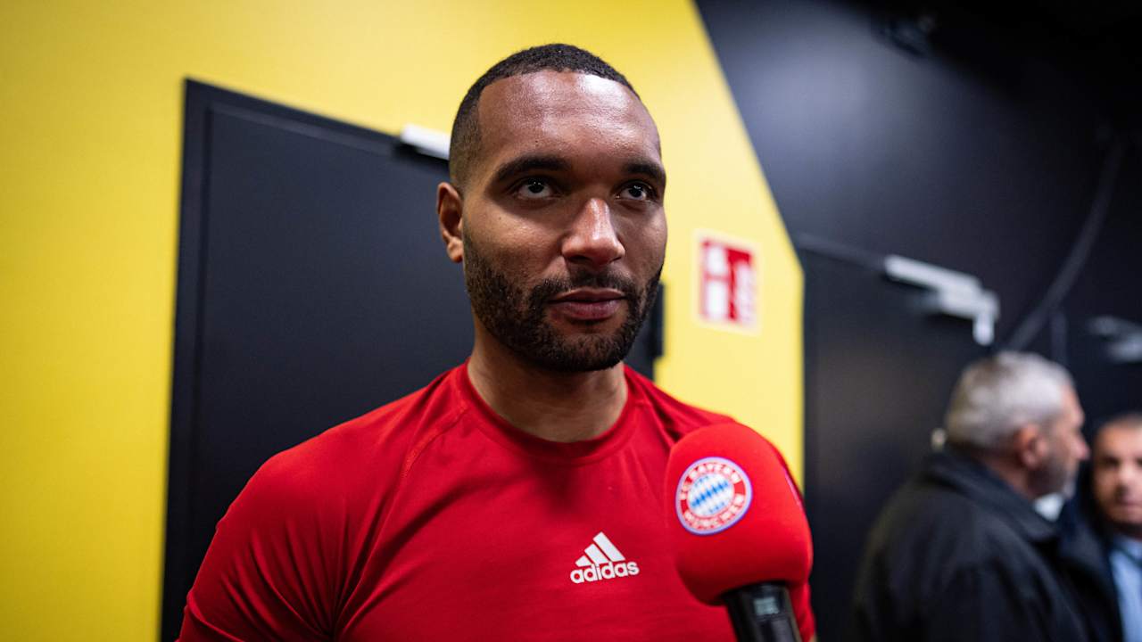 Jonathan Tah in red being interviewed after the Dortmund game