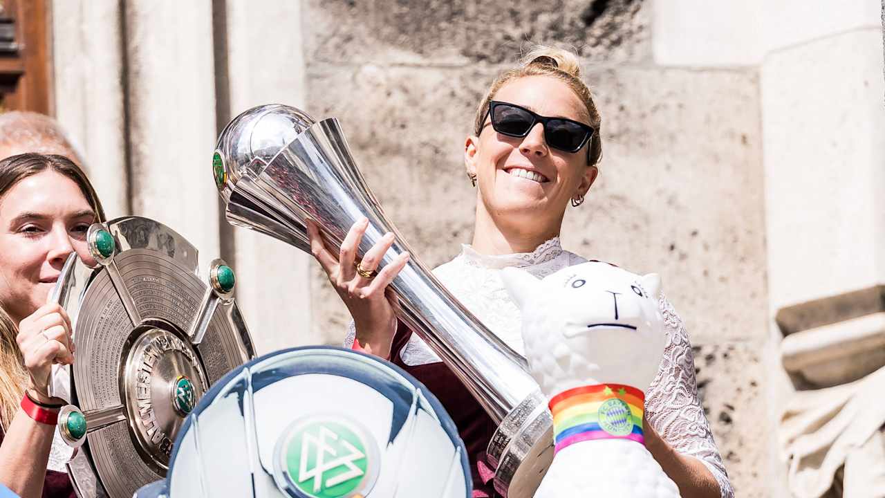 Carolin Simon mit dem DFB-Pokal in der Hand auf dem Rathausbalkon.