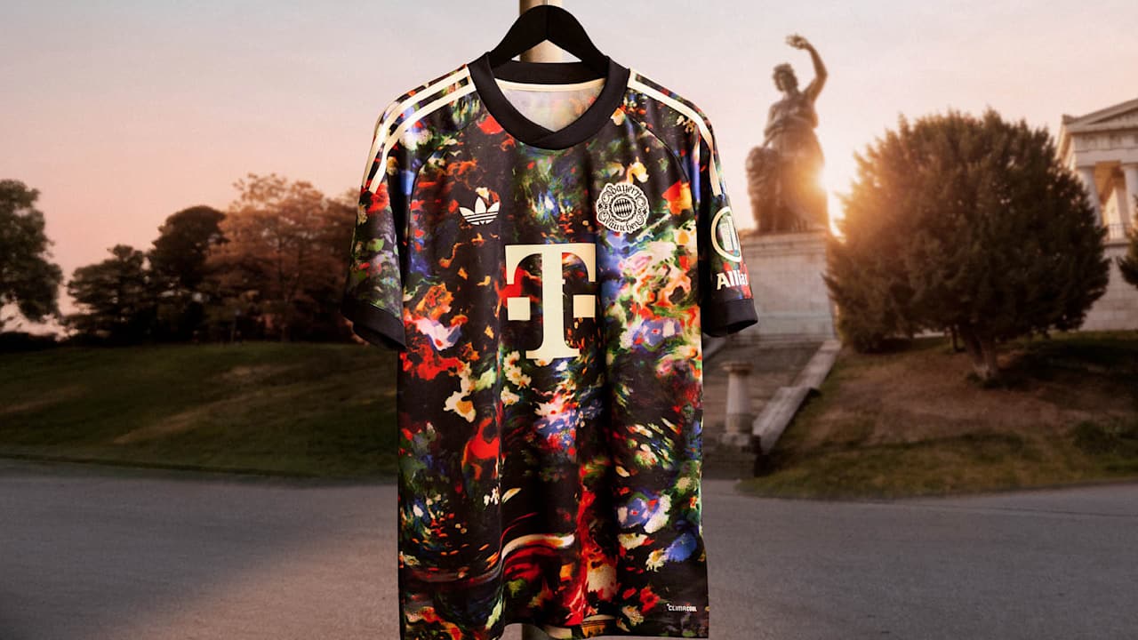 Das neue FC Bayern-Wiesn-Trikot 2026/27 mit farbenfrohem floralen Muster hängt vor der Bavaria auf der Theresienwiese