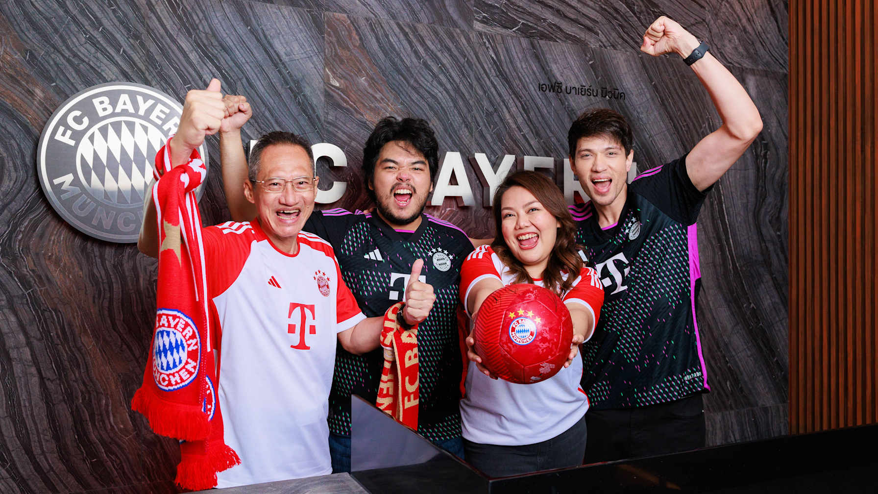 FC Bayern-Fans aus Asien jubeln in die Kamera.