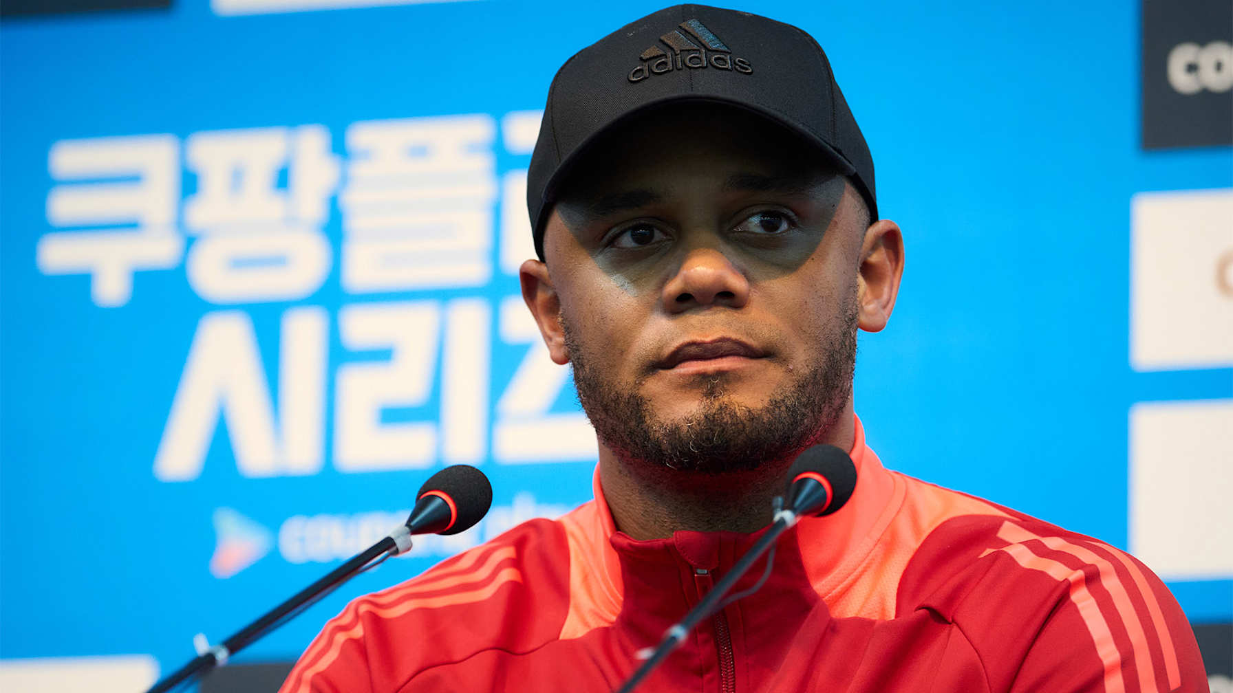 Vincent Kompany und Minjae Kim halten vor dem Testspiel gegen Tottenham in Seoul jeweils ein Trikot hoch