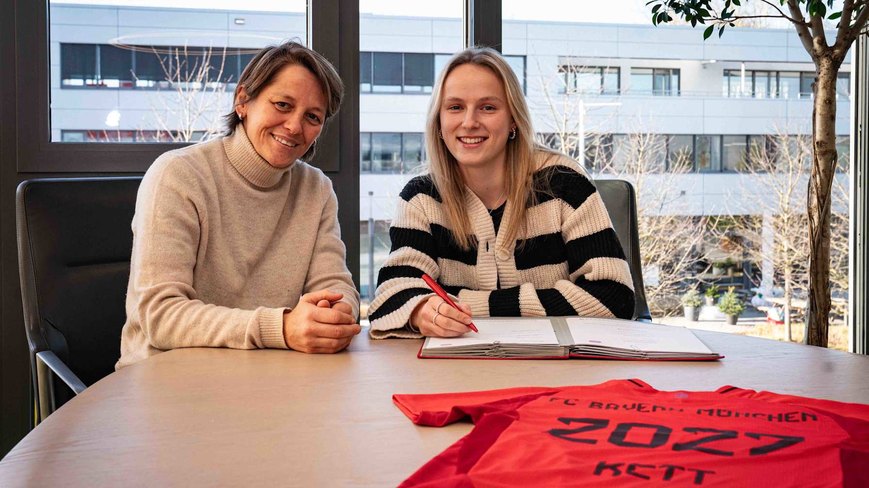 Bianca Rech and Franziska Kett smile for the camera at the contract signing
