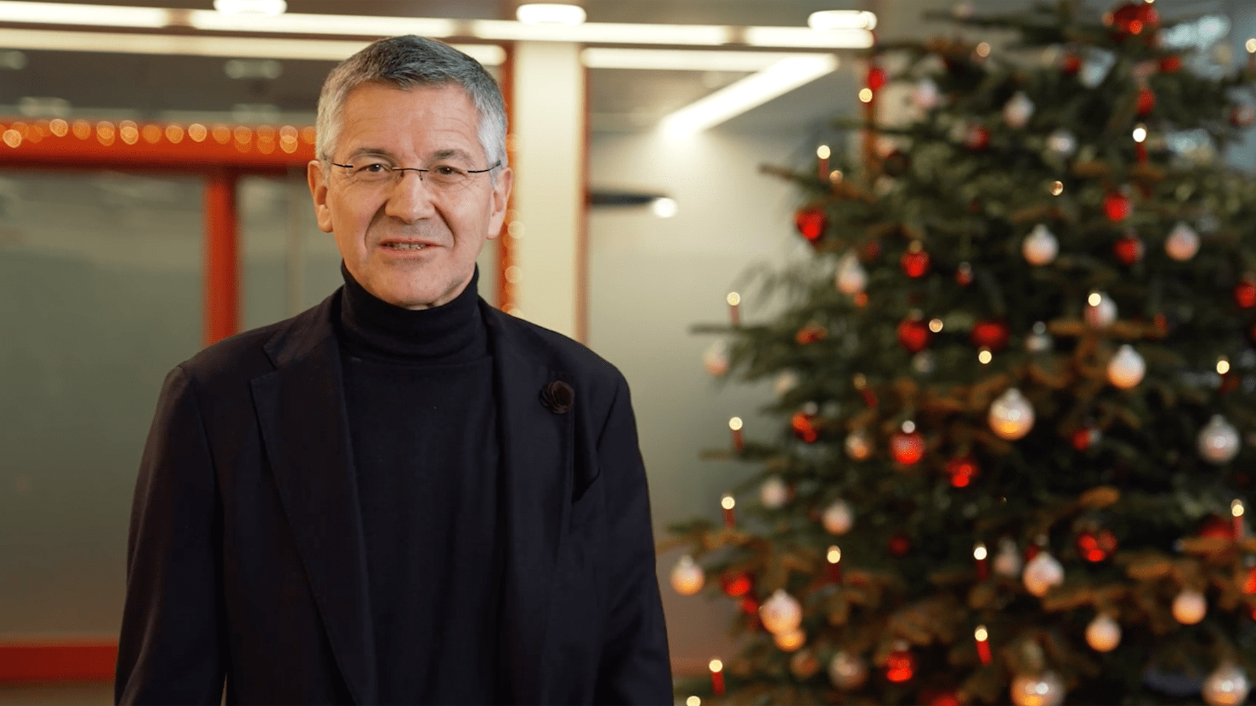 Herber Hainer spricht im Service Center des FC Bayern vor einem Weihnachtsbaum