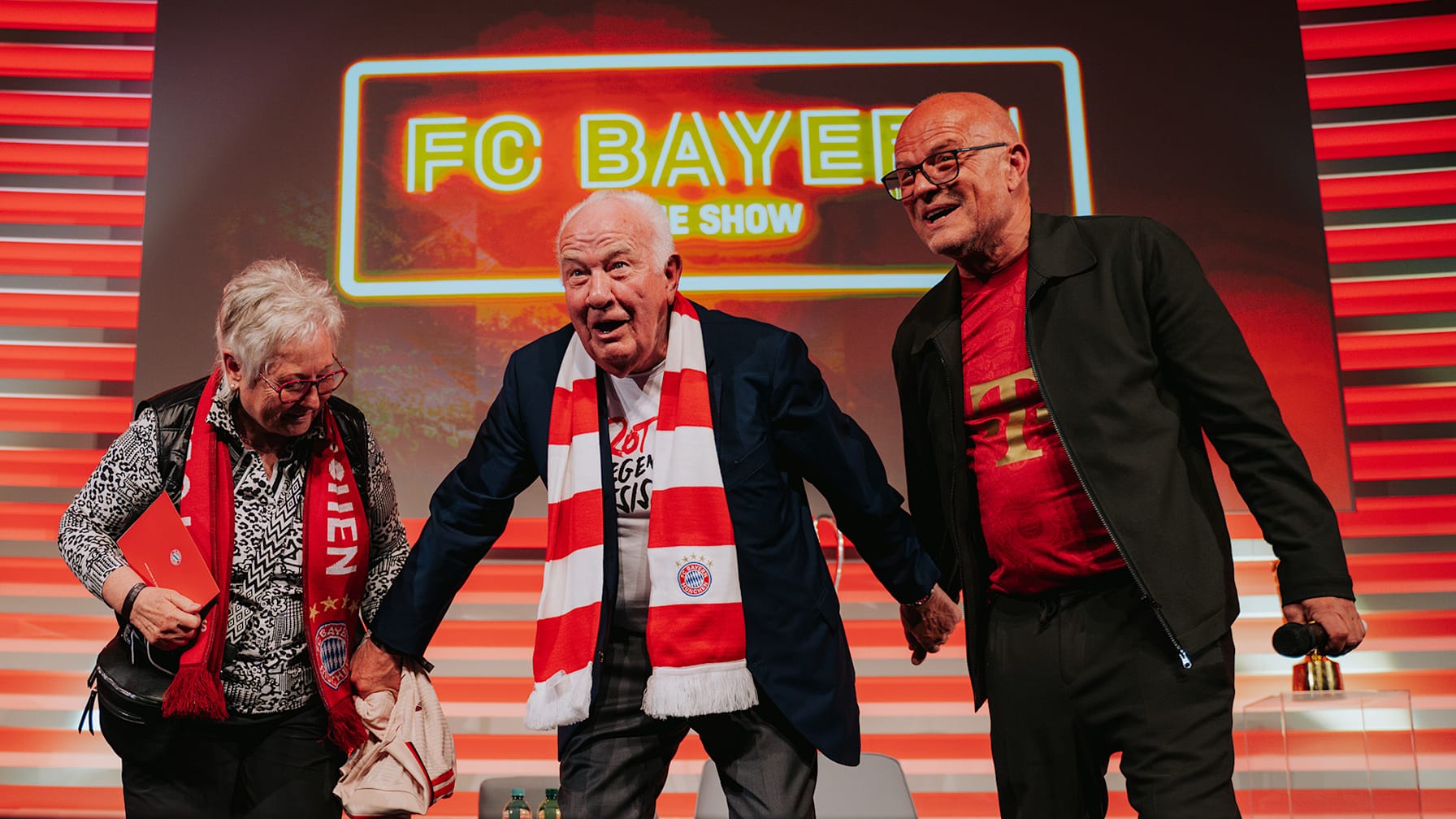 Walter Mennekes starts the Mexican wave with Stephan Lehman and a guest at the FC Bayern Show in Bonn.