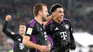 FC Bayern's goalscorers in the 2-1 win at Wolfsburg, Harry Kane and Jamal Musiala, celebrate together.