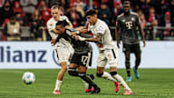 Michael Olise encara a varios rivales en el partido contra el Leverkusen.