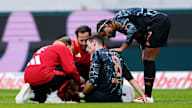 Leon Goretzka sits disappointed on the turf at Freiburg after his injury.