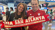 Heather Cooke y Chris Clute con camisetas y una bufanda del Bayern en la que se lee Mia san Atlanta
