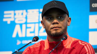 Vincent Kompany und Minjae Kim halten vor dem Testspiel gegen Tottenham in Seoul jeweils ein Trikot hoch