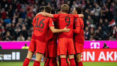 Spieler der FC Bayern bilden einen Kreis und feiern ein Tor in der Allianz Arena