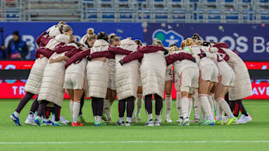Die FC Bayern Frauen schwoeren sich in einem Kreis vor dem Spiel ein.