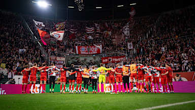Die FC Bayern-Spieler stehen Arm-in-Arm vor der Fankurve beim Auswärtsspiel in Augsburg