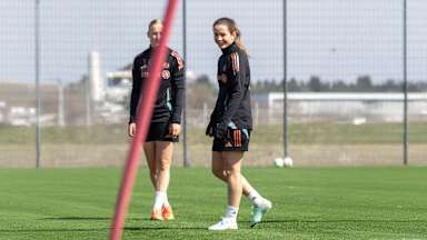 Tuva Hansen von den FC Bayern Frauen steht auf dem Trainingsplatz und lacht in die Kamera.
