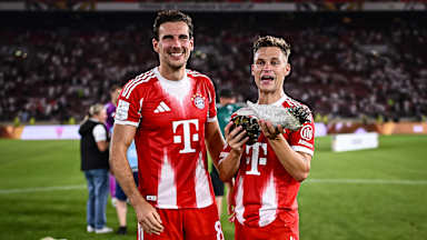 Joshua Kimmich und Leon Goretzka jubeln mit einem Kakadu auf dem Arm nach dem Gewinn des Franz-Beckenbauer-Supercup gegen den VfB Stuttgart