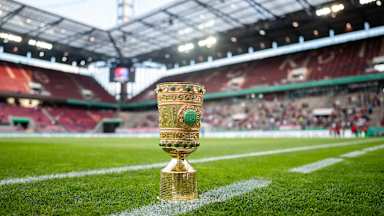Der DFB-Pokal steht am Rasenrand des Kölner Stadions.