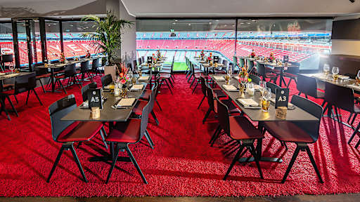 Eventbox - niedrige Tische vor Glasfront mit Blick ins Stadioninnere