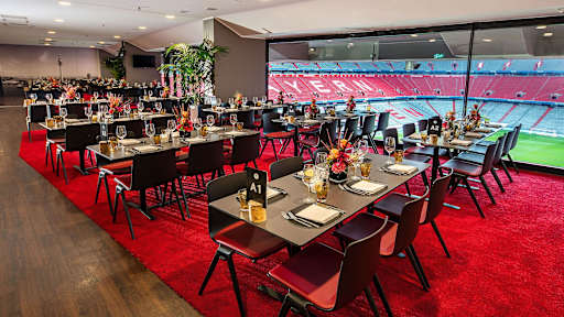 Eventbox - niedrige Tische vor Glasfront mit Blick ins Stadioninnere