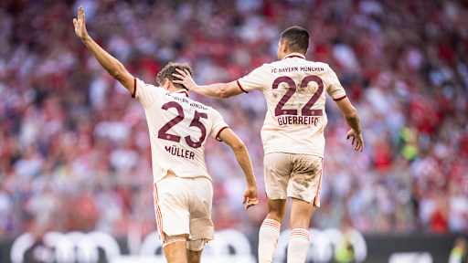 Vor einem Heimspiel des FC Bayern in der Allianz Arena stehen Fahnenträger neben dem Spielfeld.