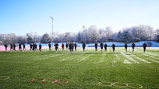 Die Spieler des FC Bayern laufen sich auf dem Platz an der Säbener Straße ein.