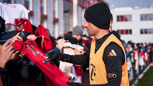 Thomas Müller unterschreibt ein Trikot eines Fan
