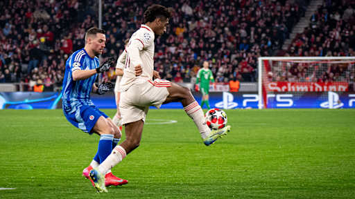 Kingsley Coman schirmt den Ball ab gegen seinen Gegenspieler im Champions League-Spiel FC Bayern gegen Slovan Bratislava